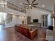Open-concept living room with a large fan, wood floors, and staircase at 8017 Talcott Dr, Mint Hill, NC 28227