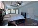 This bedroom features a decorative ceiling, ceiling fan, and a large carved bed frame at 8017 Talcott Dr, Mint Hill, NC 28227