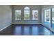 This sitting room features hardwood floors, three windows, and a door to the porch at 8017 Talcott Dr, Mint Hill, NC 28227
