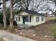 View of the house featuring a covered front porch, green door and dark shutters at 821 S Oakland St, Gastonia, NC 28054