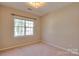 This bedroom features neutral walls, carpet flooring, and a large window at 8414 Bampton Dr, Concord, NC 28027