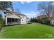 Spacious backyard featuring a lush green lawn, a screened porch, and a patio area with an umbrella table at 846 Wriston Pl, Charlotte, NC 28209