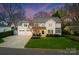 Beautiful two-story home with a three-car garage, well-maintained lawn, and mature trees at dusk at 846 Wriston Pl, Charlotte, NC 28209