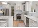 Well-lit kitchen featuring stainless steel appliances, white cabinets, and marble countertops at 846 Wriston Pl, Charlotte, NC 28209