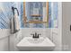 Stylish powder room with blue wallpaper, framed mirror, modern fixtures, and a clean white sink at 846 Wriston Pl, Charlotte, NC 28209