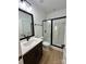 Modern bathroom with a glass shower, black fixtures, framed mirror, and luxury vinyl plank flooring at 8827 Wingard Rd, Waxhaw, NC 28173