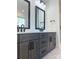 Bathroom vanity with a light countertop, black hardware, dark cabinets, and rectangular framed mirrors at 8827 Wingard Rd, Waxhaw, NC 28173