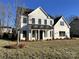 A beautiful two-story home featuring a white exterior, black roof, and a well-maintained front yard at 8827 Wingard Rd, Waxhaw, NC 28173