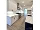 Modern kitchen boasts white cabinets, quartz countertops, stainless steel appliances, and herringbone backsplash at 8827 Wingard Rd, Waxhaw, NC 28173