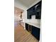 Modern kitchen with navy cabinets, wine cooler, and white countertops at 8827 Wingard Rd, Waxhaw, NC 28173