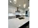 This modern kitchen features white cabinets, quartz counters, a stainless range hood, and pendant lighting at 8827 Wingard Rd, Waxhaw, NC 28173