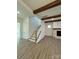 Open living room featuring exposed wood beams, staircase, and a fireplace at 8827 Wingard Rd, Waxhaw, NC 28173