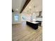 This well-lit living space showcases hardwood floors, wood beam ceilings, and a kitchen with island at 8827 Wingard Rd, Waxhaw, NC 28173