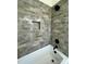 Shower with grey brick-look tile, black fixtures, and a built-in shelf over a large tub at 8827 Wingard Rd, Waxhaw, NC 28173