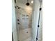 Walk-in shower has marble look tile, a bench, matte black fixtures, and built-in shampoo shelves at 8827 Wingard Rd, Waxhaw, NC 28173