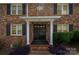 Attractive brick home with a black front door, white columns, and well-maintained landscaping at 912 Mcalway Rd # D, Charlotte, NC 28211