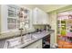 Functional kitchen featuring gray countertops, white cabinetry, a stainless steel faucet, and natural lighting at 912 Mcalway Rd # D, Charlotte, NC 28211