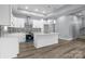 Modern kitchen features white cabinets, a large island, pendant lighting, and a stylish tile backsplash at 913 Wilson W Lee Blvd, Statesville, NC 28677