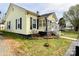 Charming yellow home featuring black shutters and a small front garden at 101 Loya St, Mount Holly, NC 28120