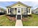 Charming yellow home with a welcoming enclosed porch and well-maintained front yard at 101 Loya St, Mount Holly, NC 28120