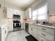 Well-lit kitchen featuring white cabinets, stainless steel appliances, and marble backsplash at 101 Loya St, Mount Holly, NC 28120