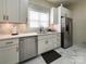 This kitchen has white cabinets, stainless steel appliances, and a marble tile backsplash at 101 Loya St, Mount Holly, NC 28120