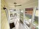 Bright enclosed porch featuring tile floors, ceiling fan, and comfortable seating area at 101 Loya St, Mount Holly, NC 28120