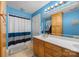 Bright blue bathroom featuring single sink vanity with storage and a shower with blue and white curtains at 102 Wyndham Way, Salisbury, NC 28147
