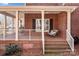 Inviting front porch with a wooden swing, brick steps, and brick walls at 102 Wyndham Way, Salisbury, NC 28147