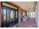 Inviting front porch with brick flooring, white railings, and comfortable seating, perfect for relaxing outdoors at 102 Wyndham Way, Salisbury, NC 28147