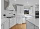 Bright kitchen featuring stainless steel appliances, white cabinetry, a farmhouse sink and hardwood floors at 102 Wyndham Way, Salisbury, NC 28147