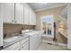 Neat laundry room featuring a sink, washer, dryer, neutral paint, shelving and natural light at 102 Wyndham Way, Salisbury, NC 28147