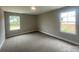 Spacious bedroom with soft carpeting, neutral paint, and bright natural light from large windows at 11533 Valley Oaks Ln, Stanfield, NC 28163