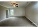 Large bedroom with neutral walls, soft carpeting, ceiling fan, and bright natural light at 11533 Valley Oaks Ln, Stanfield, NC 28163
