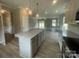 Open-concept kitchen with a center island, stainless appliances, and sightlines into the living area at 11533 Valley Oaks Ln, Stanfield, NC 28163