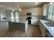 Beautiful kitchen featuring granite countertops, a center island, and stainless steel appliances, open to the living room at 11533 Valley Oaks Ln, Stanfield, NC 28163