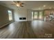 Bright, open-concept living room featuring a fireplace and plank flooring, with easy access to the kitchen at 11533 Valley Oaks Ln, Stanfield, NC 28163