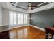 Bright bedroom featuring plantation shutters, wood floors, and a trey ceiling at 11609 Mersington Ln, Charlotte, NC 28277