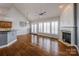 Spacious living room with hardwood floors, fireplace, and large windows with plantation shutters at 11609 Mersington Ln, Charlotte, NC 28277