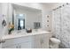 Modern bathroom features double sinks, a white vanity, and a blue-patterned shower curtain at 12425 Larue Ln, Huntersville, NC 28078