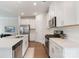 Well-lit kitchen with white cabinets, stainless steel appliances, and hardwood flooring at 12425 Larue Ln, Huntersville, NC 28078