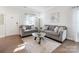Comfortable living room featuring hardwood floors, modern sofas, and a glass coffee table at 12425 Larue Ln, Huntersville, NC 28078