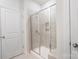 Modern tiled walk-in shower with a glass door at 12425 Larue Ln, Huntersville, NC 28078