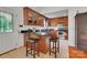 Eat-in kitchen with wood cabinets, black countertop, island with breakfast bar, and stainless steel appliances at 136 Nicks Rd, Norwood, NC 28128