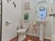 This bathroom features a toilet, pedestal sink, and decorative artwork at 137 Mossy Pond Rd, Statesville, NC 28677