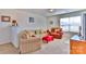 A carpeted living room features a sofa, armchair, and natural light through windows at 137 Mossy Pond Rd, Statesville, NC 28677