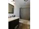 Bathroom featuring a dark wood vanity, white sink, and tiled flooring, along with a shower with a gray curtain at 14440 W Highway 55 Hwy, Blacksburg, SC 29702