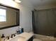 Well-lit bathroom featuring a dark-framed mirror, a white countertop, and a shower with a gray curtain at 14440 W Highway 55 Hwy, Blacksburg, SC 29702