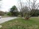 A view of the front yard facing the road with mature trees and a mulched flower bed at 14440 W Highway 55 Hwy, Blacksburg, SC 29702