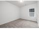 This bedroom features neutral carpet, white walls, one window, and a flush mount ceiling light at 1505 W May Ave, Gastonia, NC 28052
